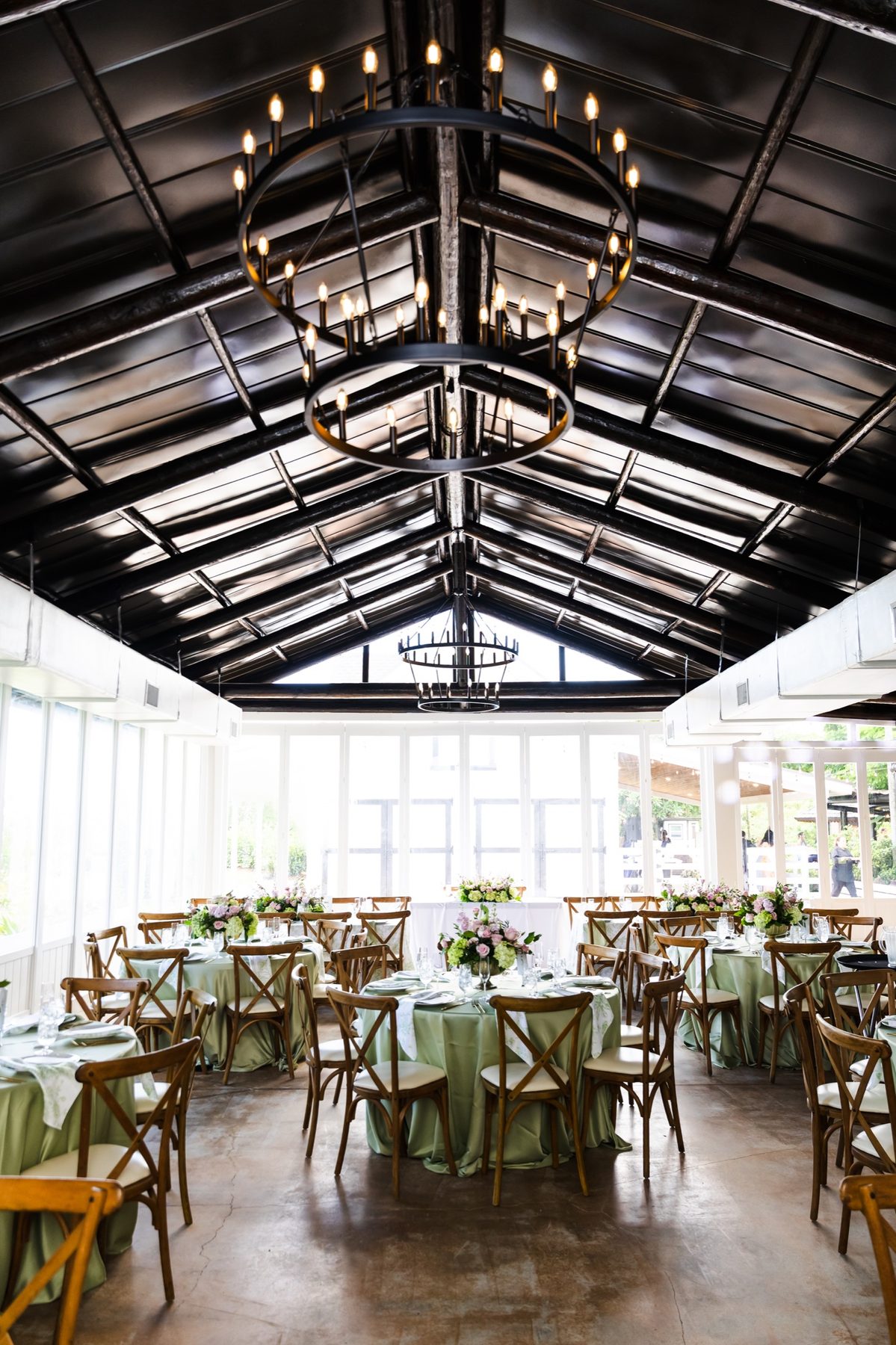 A wedding reception arranged beneath chandeliers inside The Estate Room