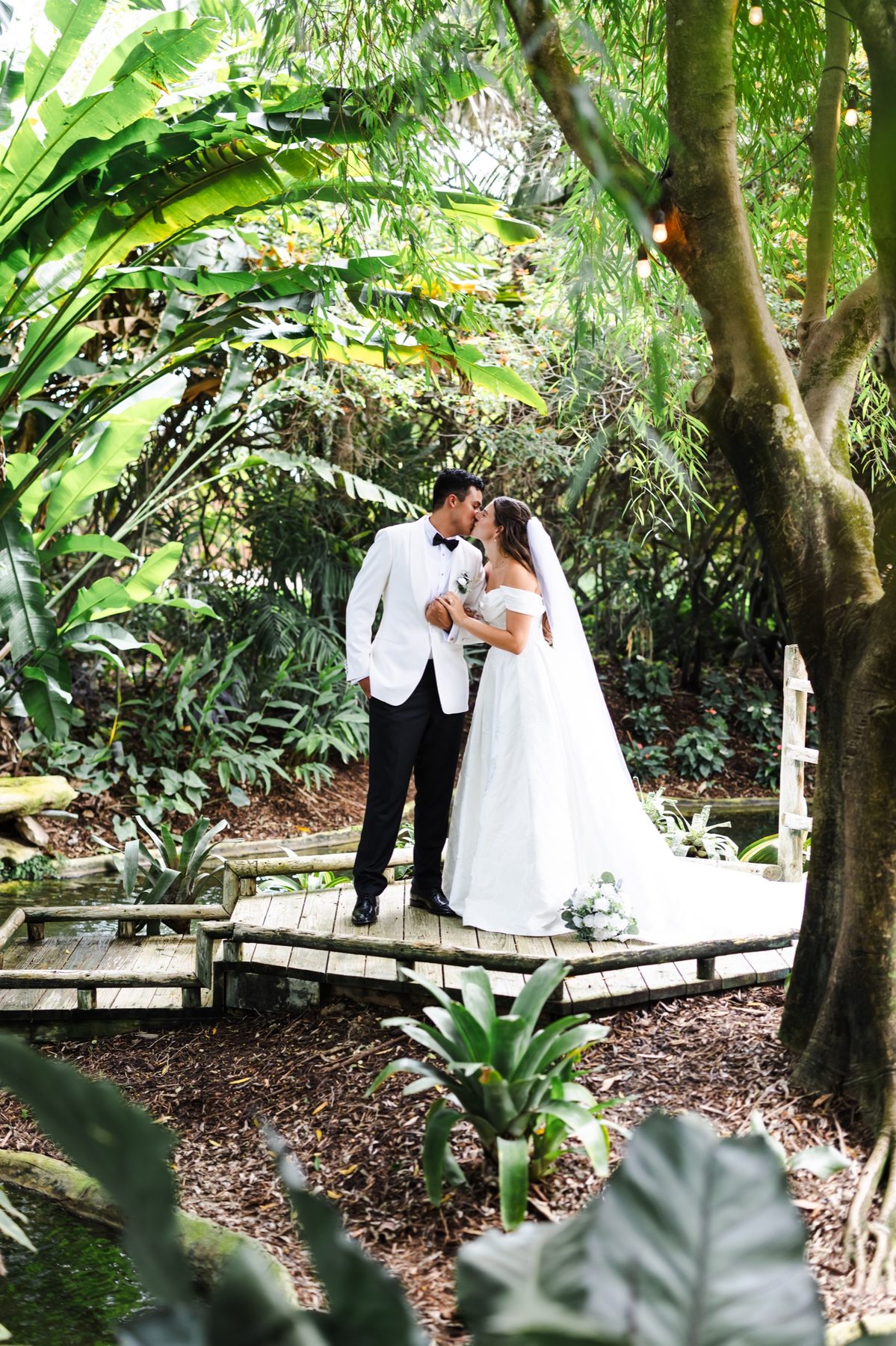 Newlyweds standing together within the tropical gardens at The Arbor Estate