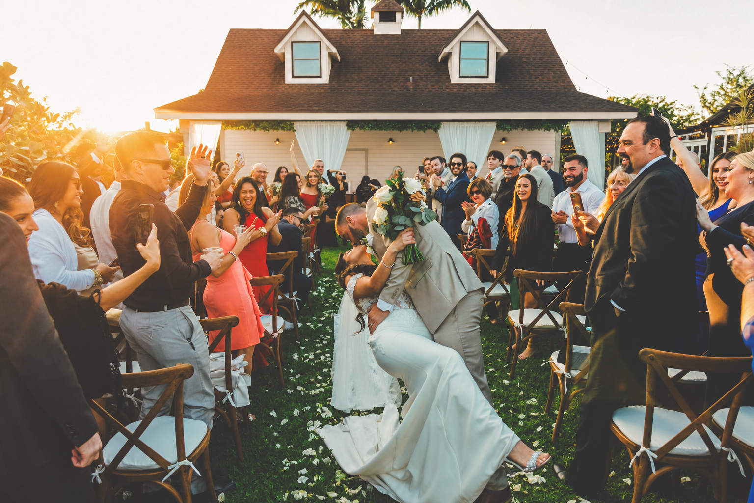 Newlyweds celebrating with their guests outside The Arbor Estate's signature white building