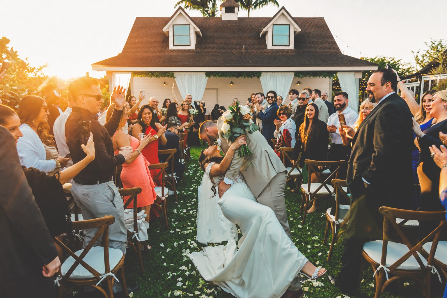 Newlyweds celebrating at the end of their garden ceremony aisle at The Arbor Estate