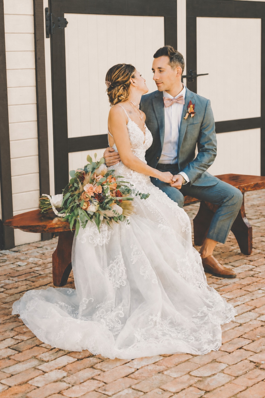 Newlyweds seated together in front of the estate's signature white doors