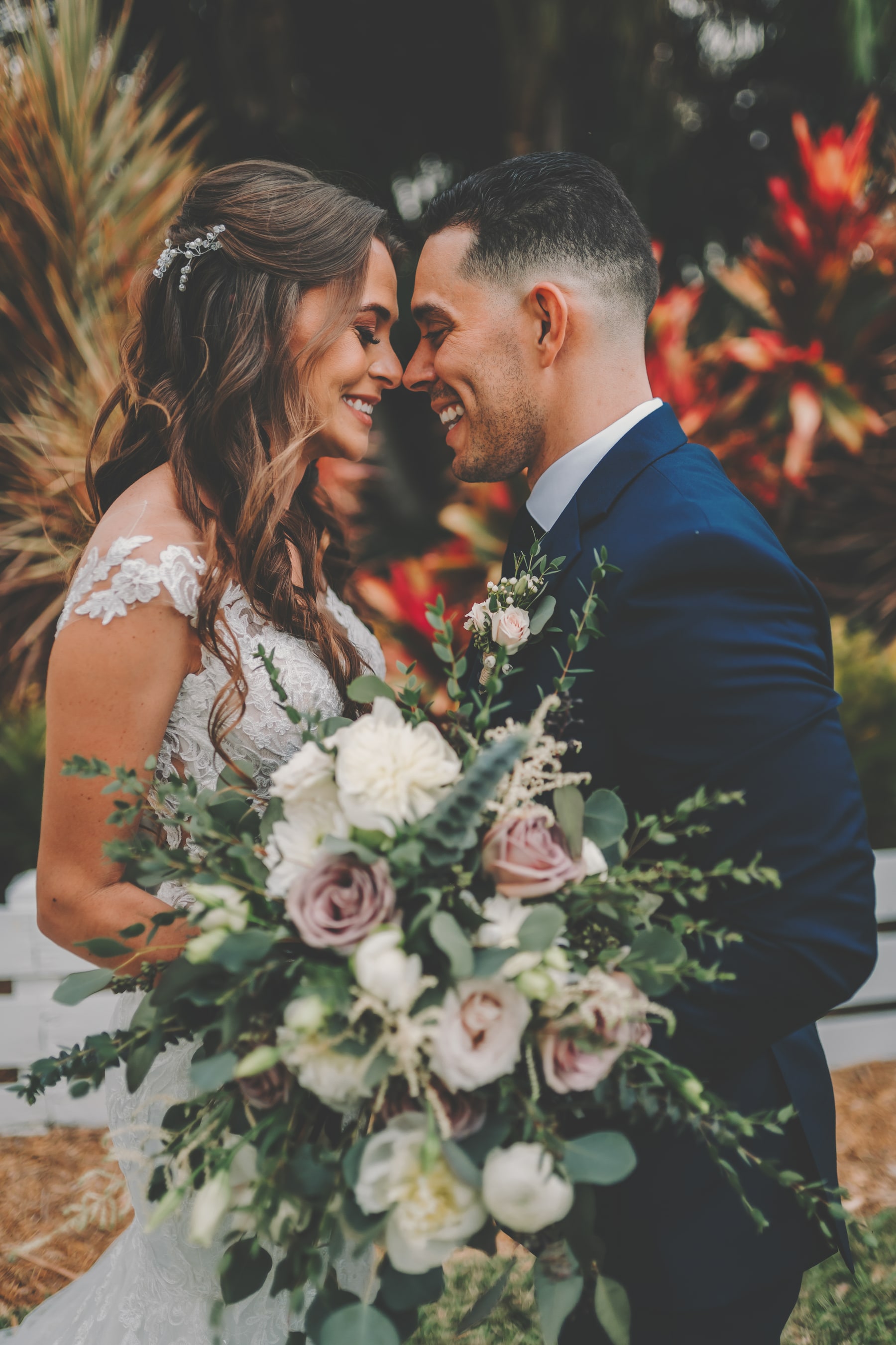 Newlyweds sharing a close, joyful moment in the estate gardens