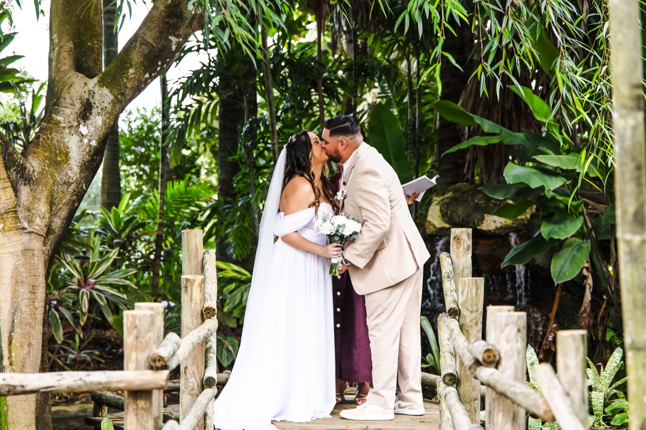 Kaila and Vincent sharing their first kiss on the garden bridge at The Arbor Estate
