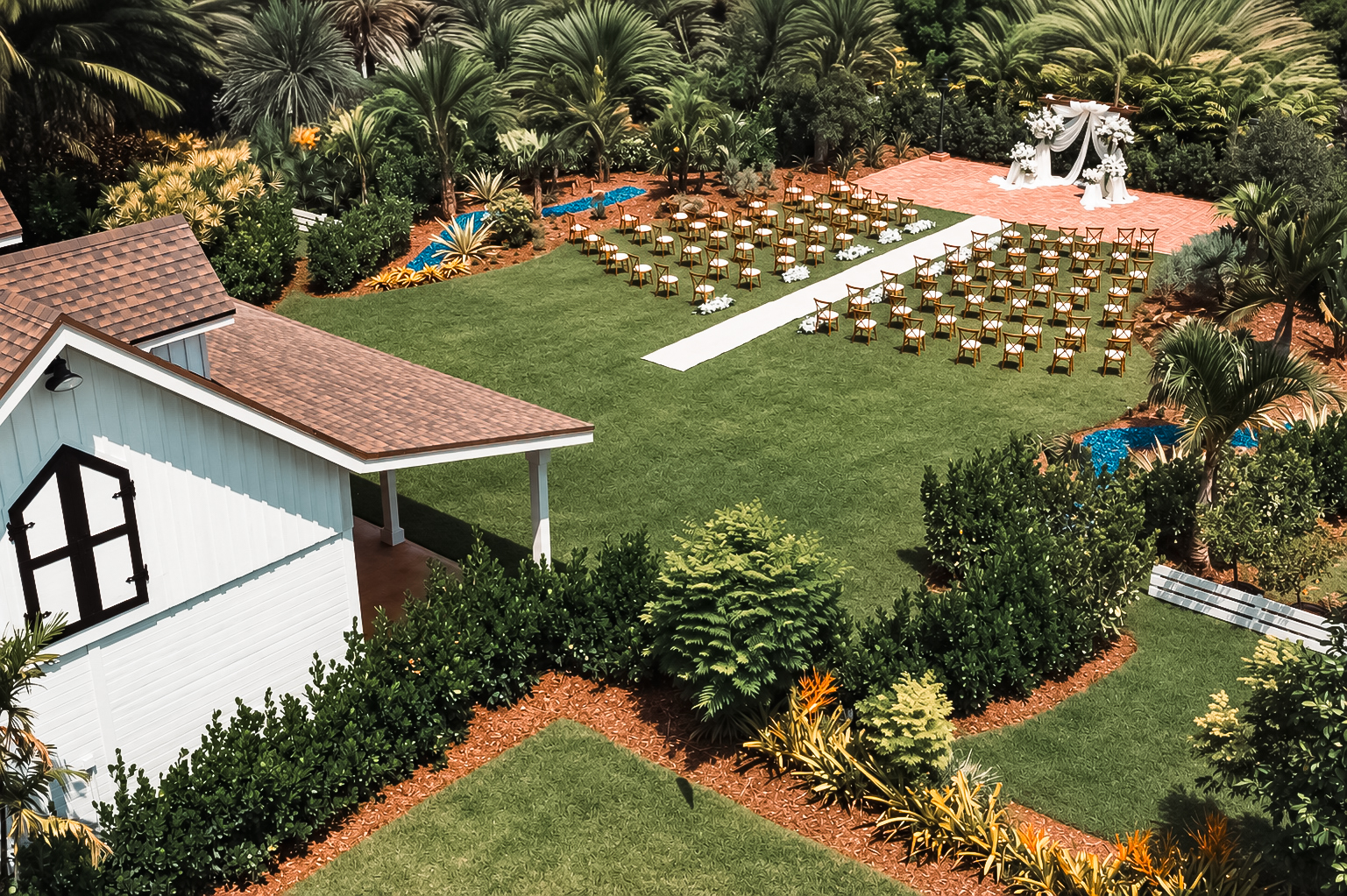 Aerial view of the garden ceremony set with chairs, a white aisle, and a floral arbor at The Arbor Estate