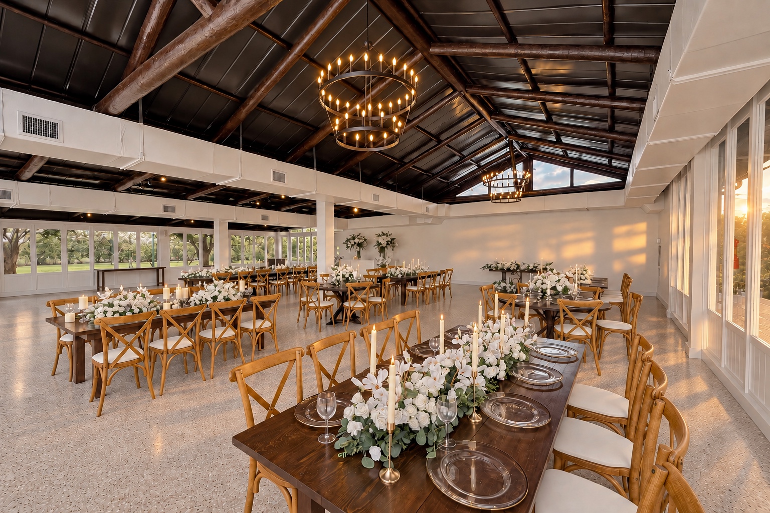 Golden-hour light across candlelit tables and white floral arrangements in The Arbor Estate reception room